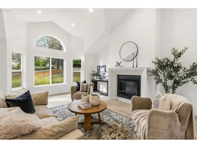 a living room with furniture a fireplace and a large window
