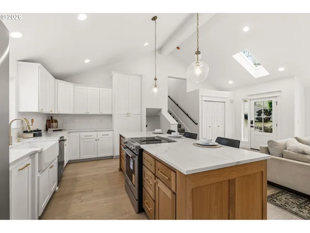 a kitchen with a stove a sink a kitchen island with wooden cabinets