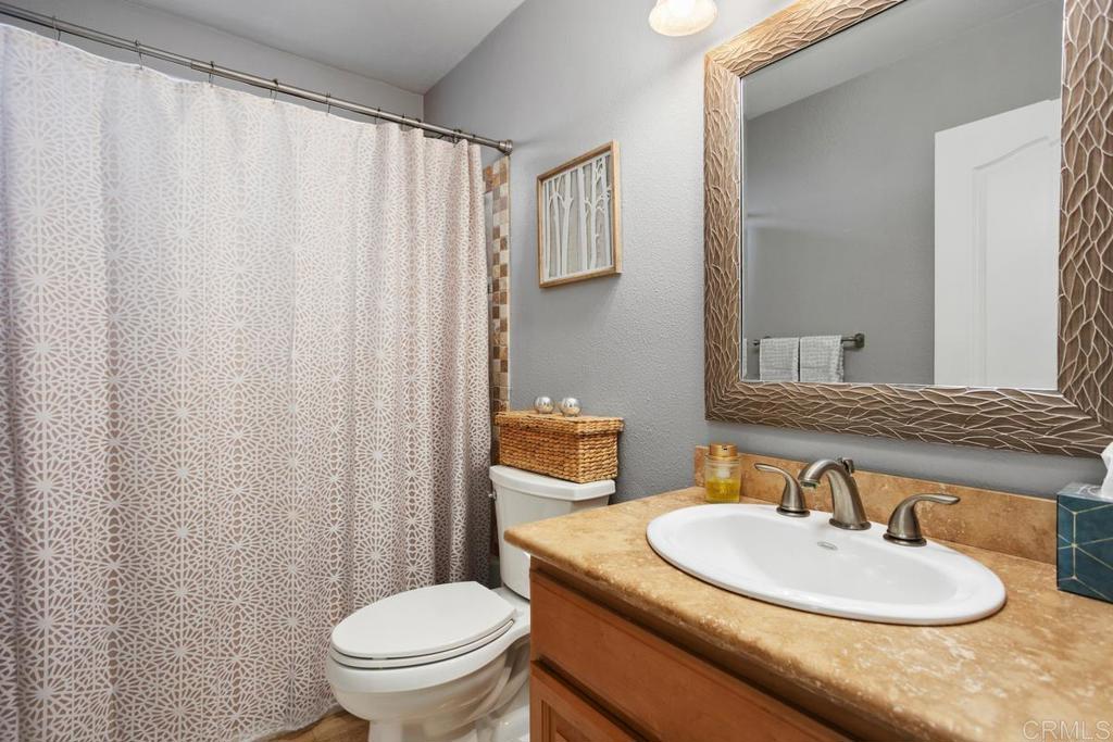 2804 Jacaranda Avenue Carlsbad, CA 92009 - Photo 22 of 36 a bathroom with a toilet a sink and a mirror
