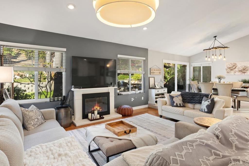 2804 Jacaranda Avenue Carlsbad, CA 92009 - Photo 9 of 36 a living room with couches a fireplace and a flat screen tv