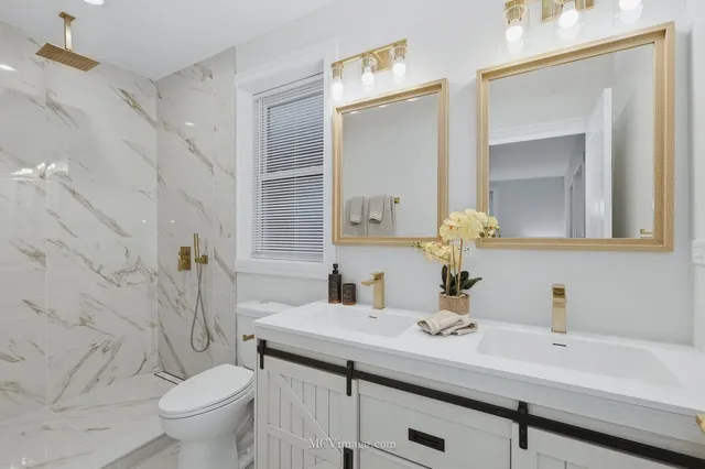 a bathroom with a granite countertop sink a toilet and a mirror