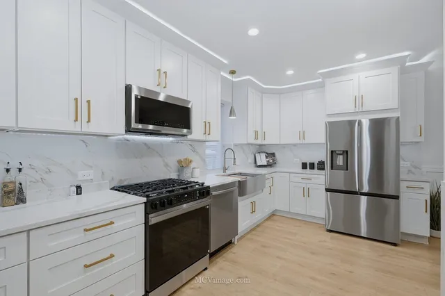 a kitchen with white cabinets and stainless steel appliances