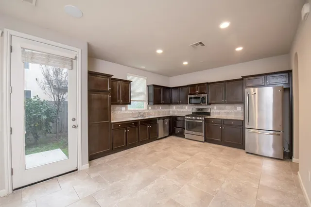 a kitchen with stainless steel appliances granite countertop a refrigerator and a sink