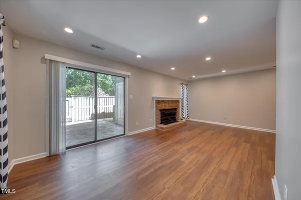 an empty room with wooden floor and fireplace