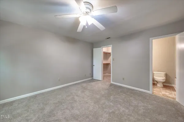 an empty room with a ceiling fan and window