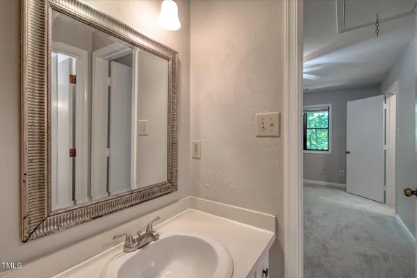 an empty room with a chandelier fan and windows