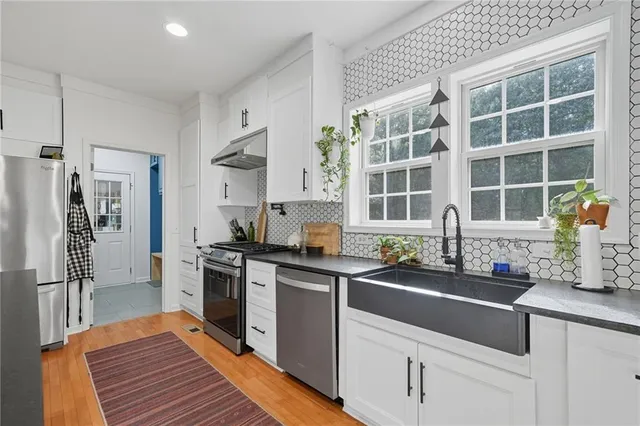 a kitchen with stainless steel appliances a sink stove and cabinets