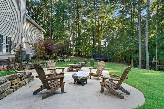 a view of a patio with a table chairs and a fire pit