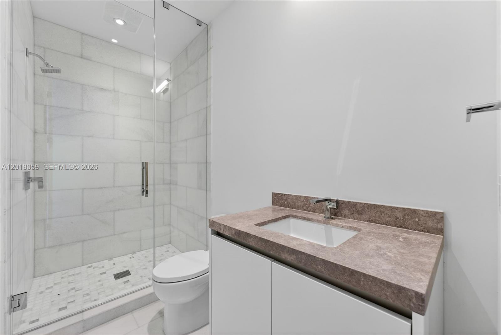 175 Southeast 25th Road, Unit 1004 Miami, FL 33129 - Photo 20 of 40 a bathroom with a granite countertop sink a toilet and shower