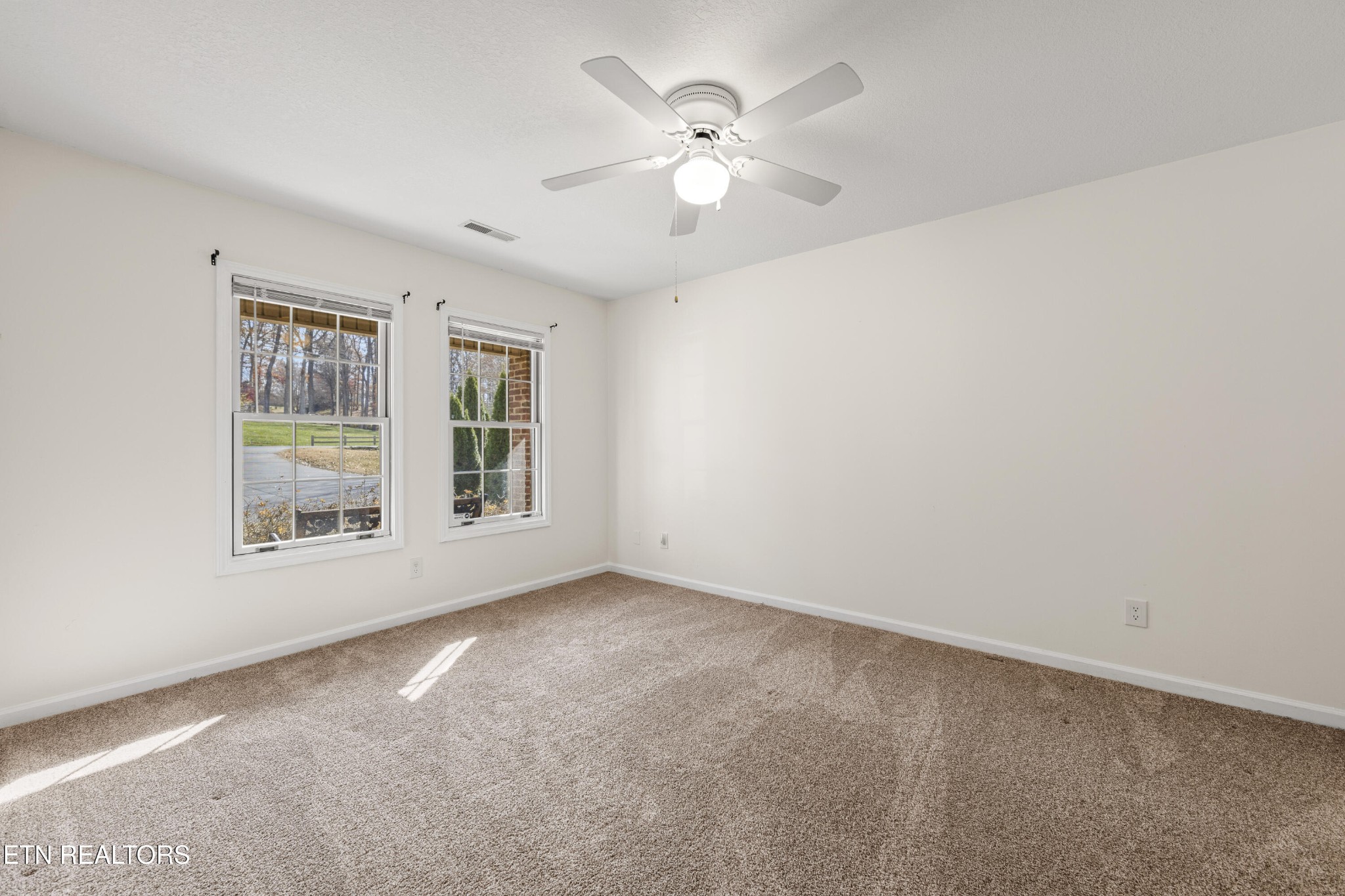 1218 Ernest McMahan Road Sevierville, TN 37862 - Photo 5 of 40 an empty room with chandelier fan and windows