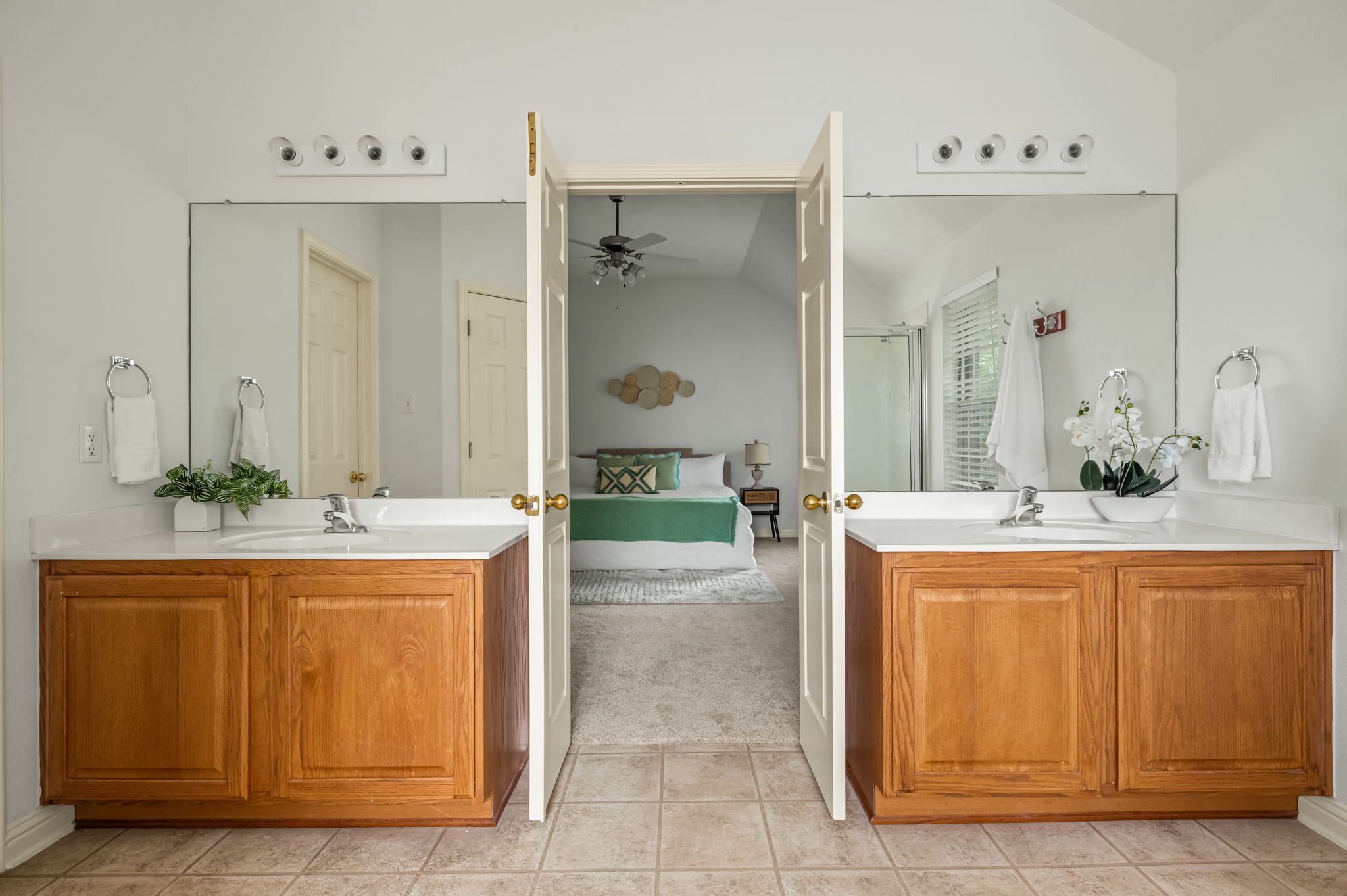 10004 Isle Royale Way Austin, TX 78747 - Photo 23 of 31 Dual vanities and neutral tones craft a serene and functional primary bathroom, offering a seamless transition to the restful bedroom beyond.