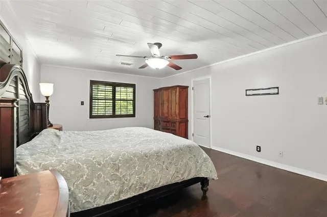 a bedroom with a large bed window and a chandelier