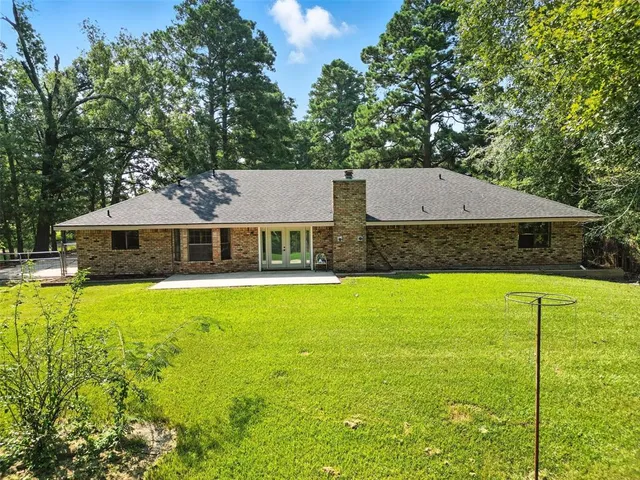 a aerial view of a house with swimming pool next to a yard