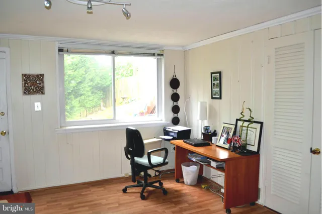 a view of a workspace with furniture and a window