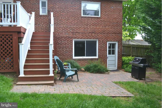 a view of a patio with table and chairs and wooden fence