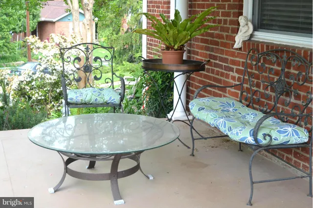 a backyard of a house with table and chairs plants