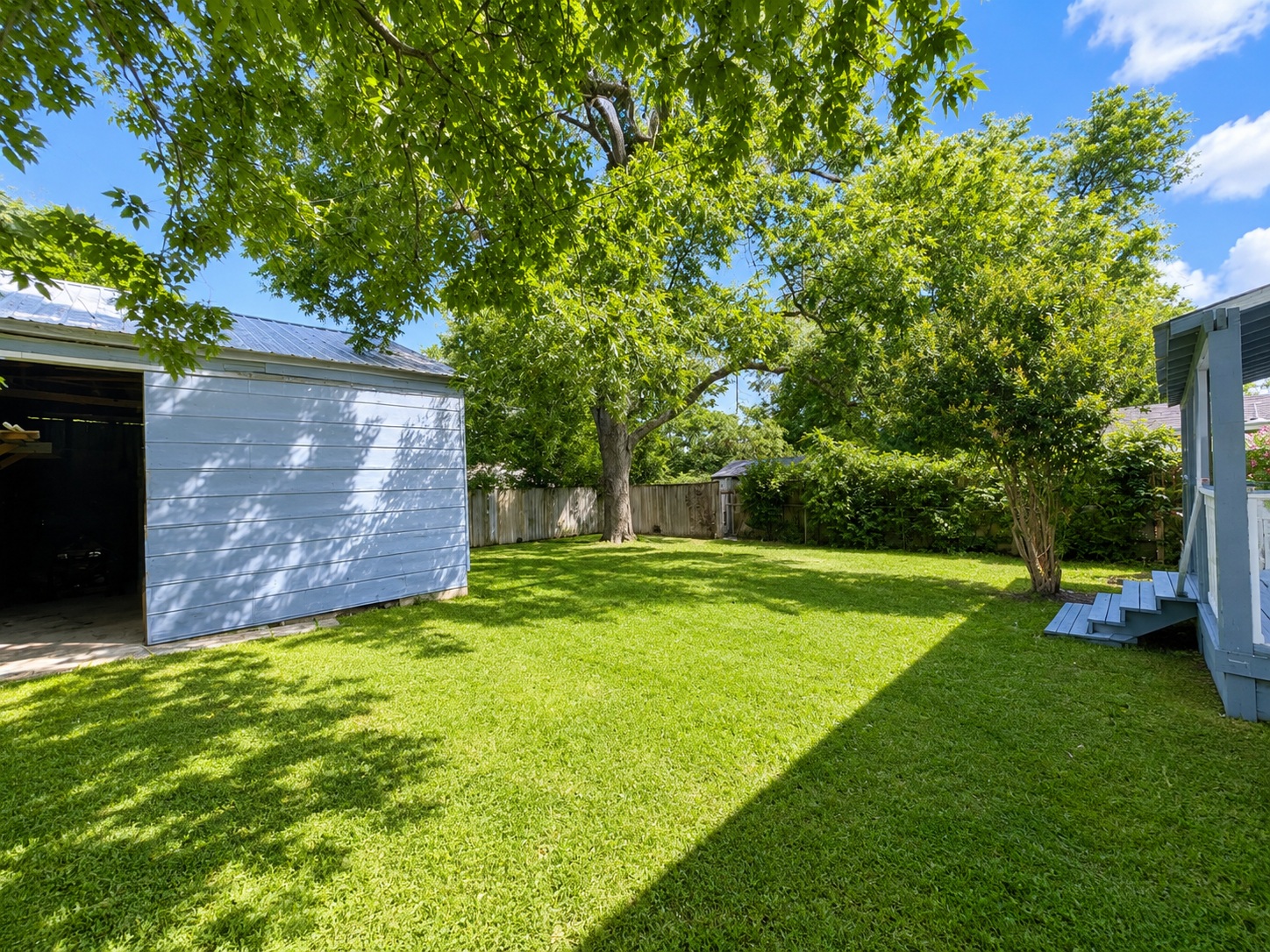 810 North 6th Street Temple, TX 76501 - Photo 8 of 9 A verdant backyard with ample space, featuring a convenient storage shed and a charming wooden deck.