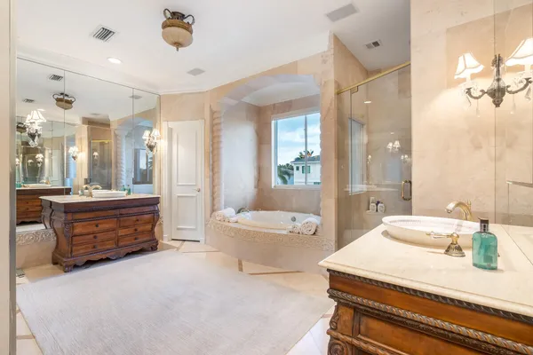a bathroom with a tub sink shower and mirror
