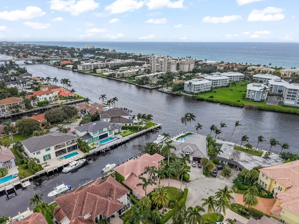 an aerial view of a city with lots of residential buildings ocean and mountain view in back
