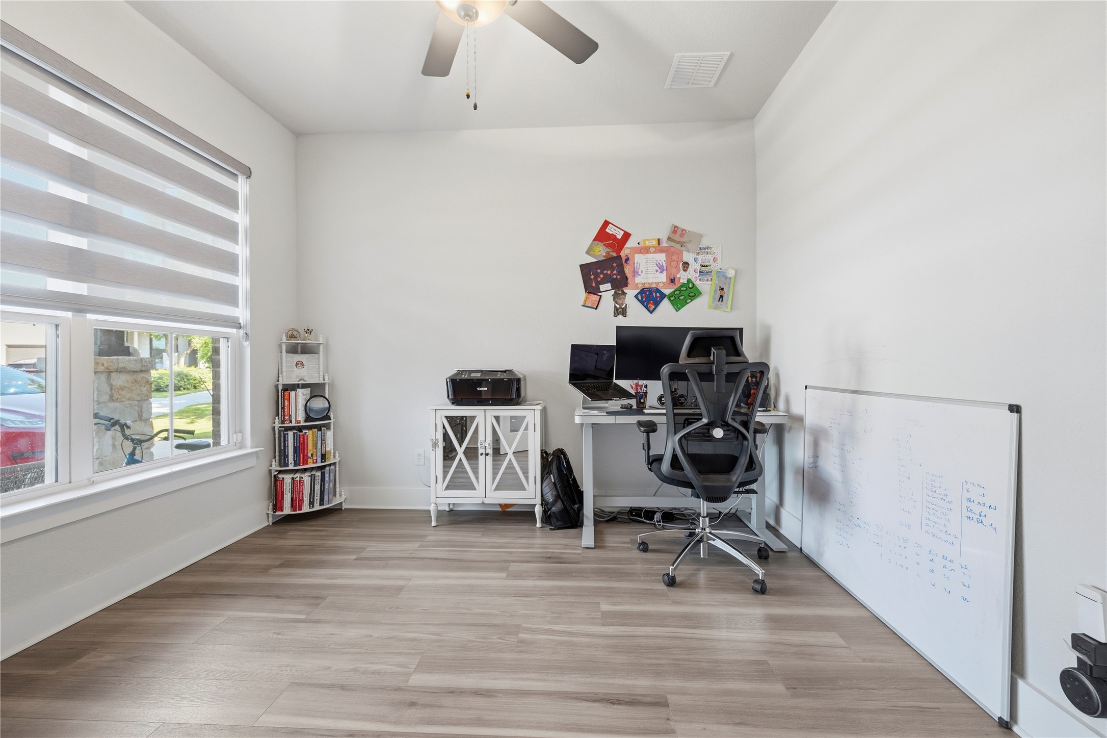 105 Autumn Oak Way Georgetown, TX 78628 - Photo 4 of 40 Bright room featuring wood-finish flooring, white walls, and a ceiling fan with integrated lighting