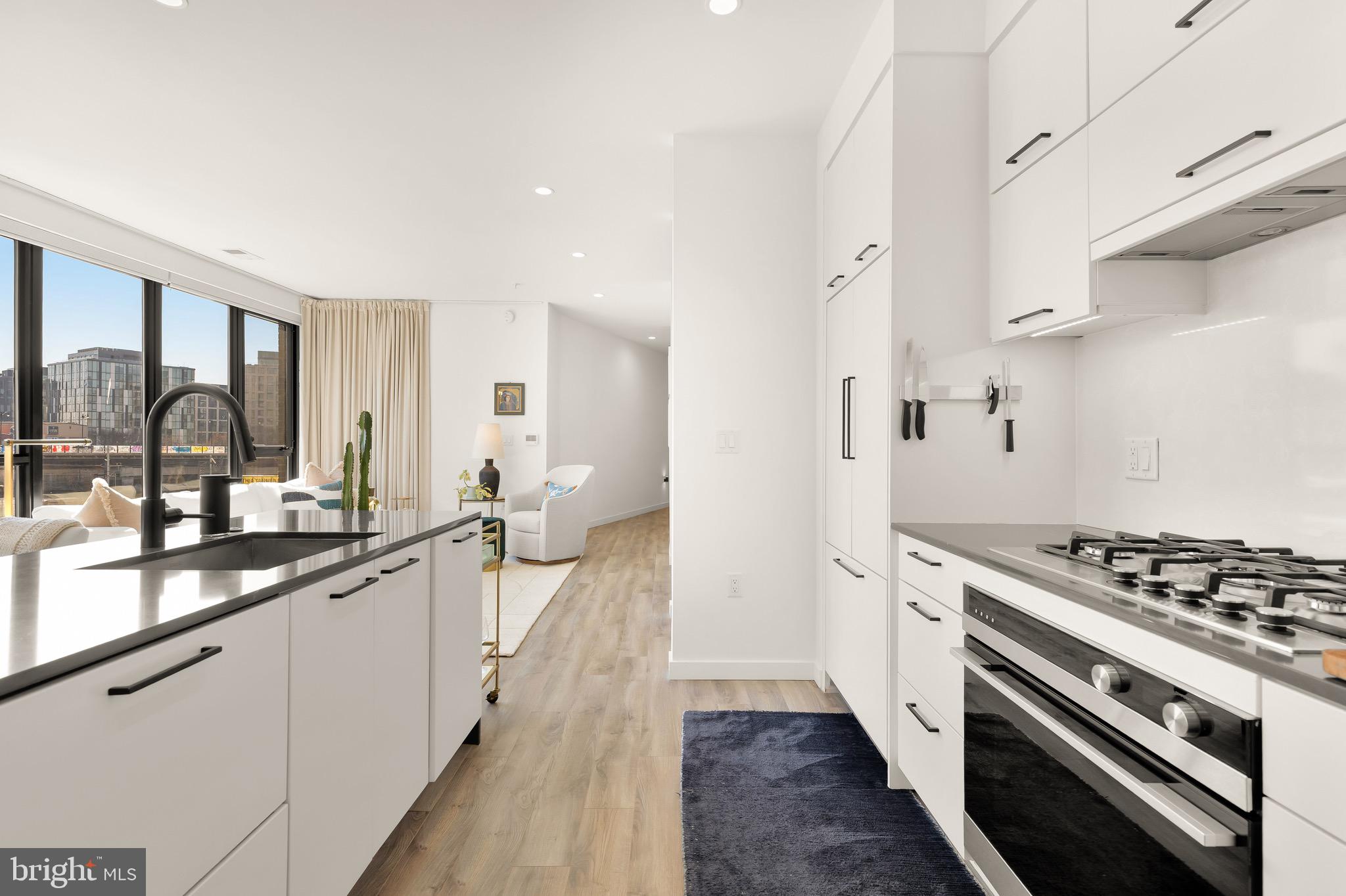1500 Harry Thomas Way Northeast, Unit 501 Washington, DC 20002 - Photo 13 of 44 a large kitchen with stainless steel appliances a stove a sink dishwasher and wooden cabinets with wooden floor