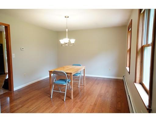 115 Fitzgerald Road Charlton, MA 01507 - Photo 9 of 24 a dining room with wooden floor a chandelier a wooden table and chairs