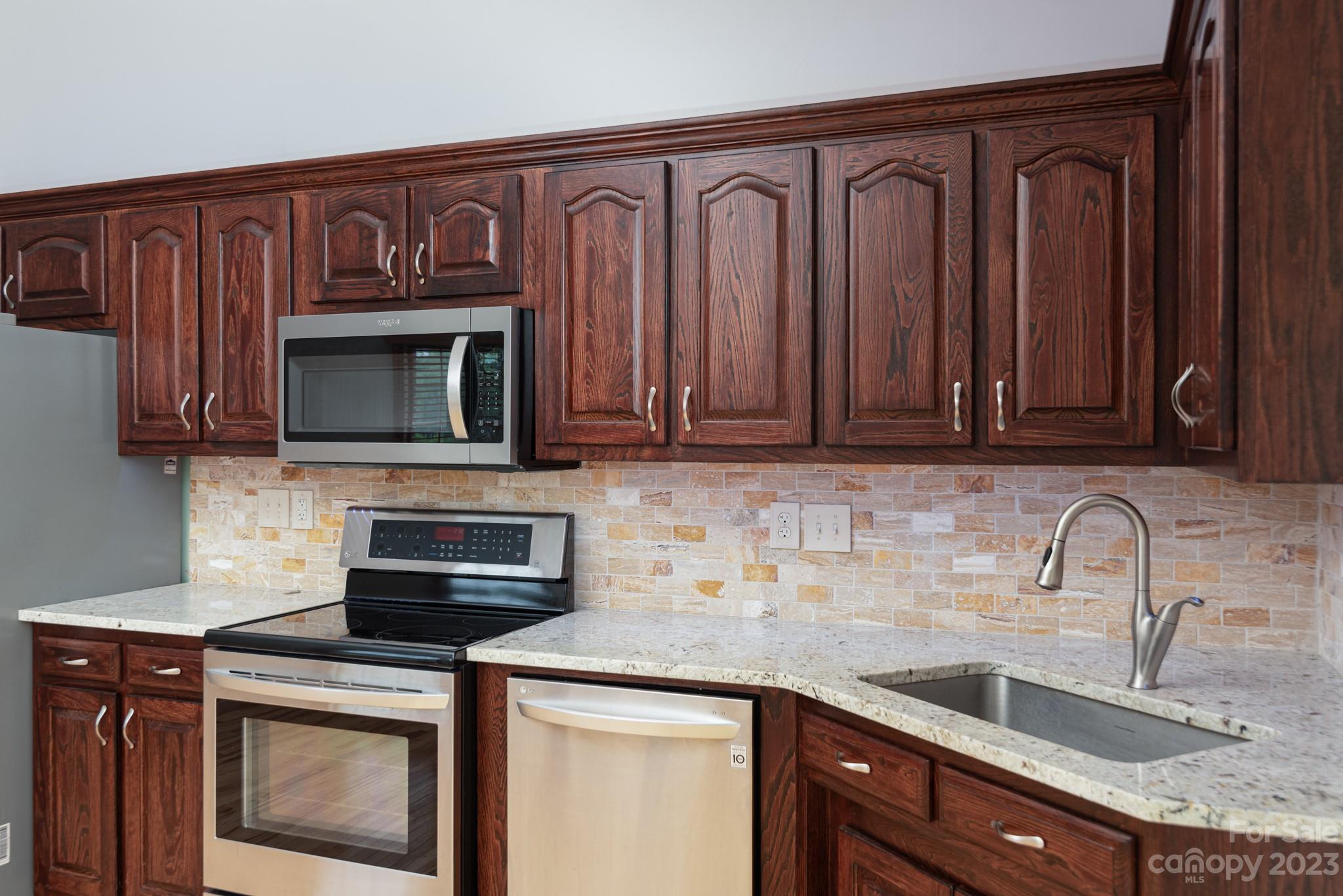 920 Bethel Church Road Lincolnton, NC 28092 - Photo 11 of 27 a kitchen with stainless steel appliances granite countertop a sink stove and microwave
