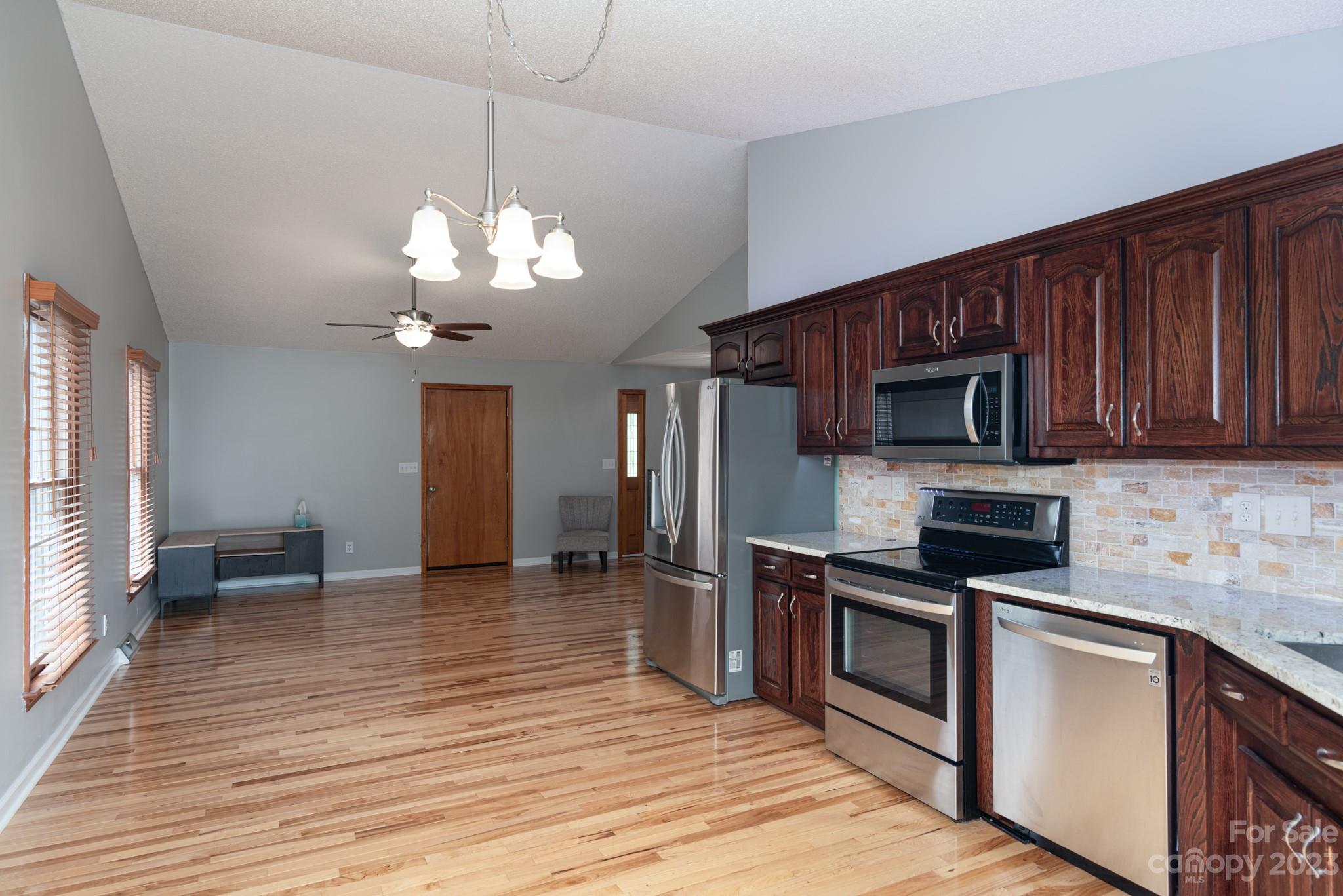 920 Bethel Church Road Lincolnton, NC 28092 - Photo 12 of 27 a kitchen with stainless steel appliances granite countertop a stove top oven a sink dishwasher and a microwave oven on the wooden floor