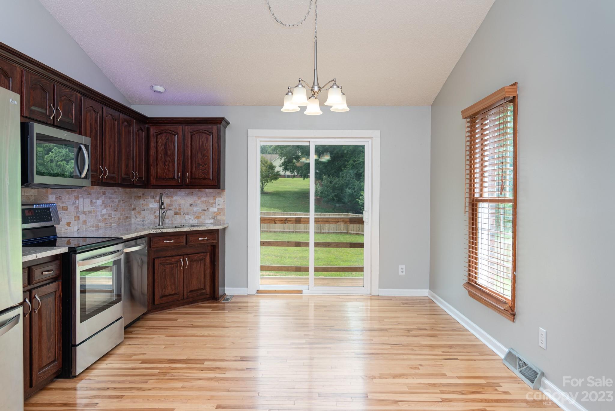 920 Bethel Church Road Lincolnton, NC 28092 - Photo 9 of 27 a open kitchen with granite countertop a stove top oven a sink and dishwasher with wooden floor