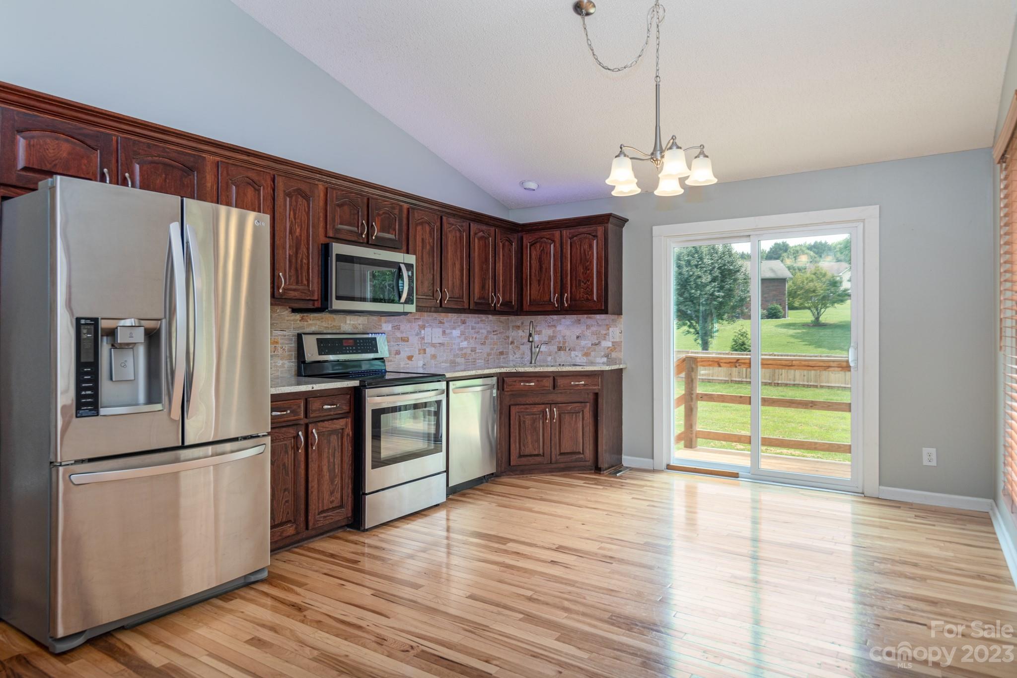 920 Bethel Church Road Lincolnton, NC 28092 - Photo 10 of 27 a kitchen with stainless steel appliances granite countertop a refrigerator a stove top oven a sink dishwasher and wooden floor