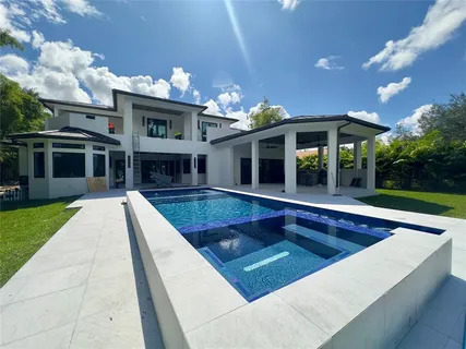 a view of a house with swimming pool and porch with furniture