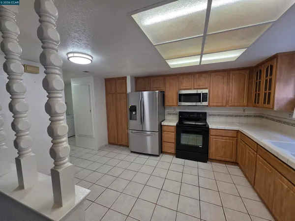 a kitchen with stainless steel appliances granite countertop a refrigerator and a sink