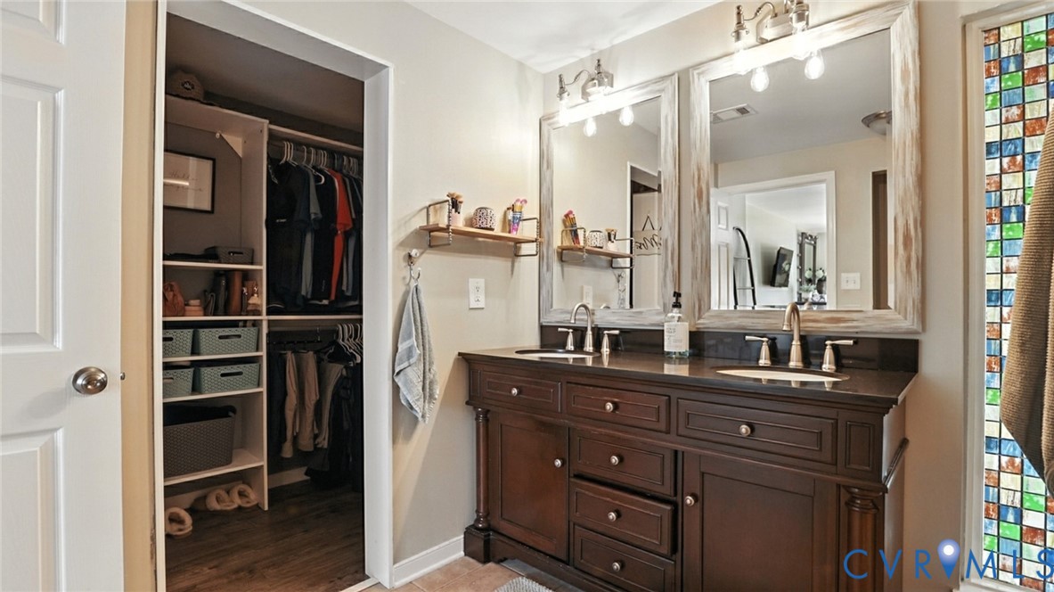 9743 Snowhill Road Richmond, VA 23235 - Photo 38 of 48 Bathroom with double vanity, a walk in closet, and