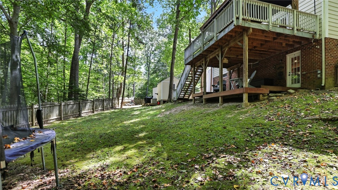 9743 Snowhill Road Richmond, VA 23235 - Photo 45 of 48 Fenced backyard featuring a wooden deck, a trampol