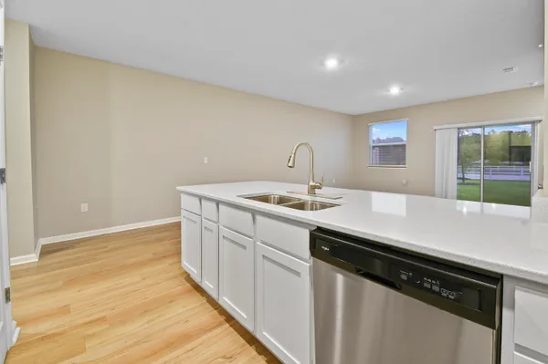 a kitchen with a sink cabinets and wooden floor