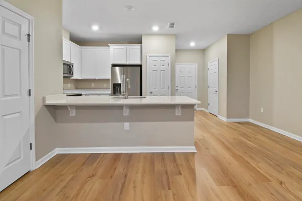 a view of kitchen with granite countertop cabinets and wooden floor