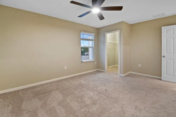 an empty room with windows and fan