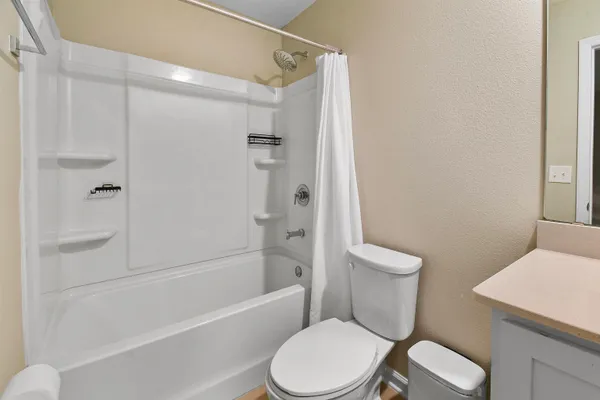 a white toilet and tub next to a bathroom sink