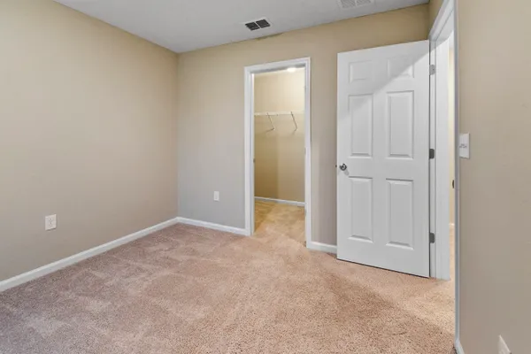 an empty room with closet and a bathroom