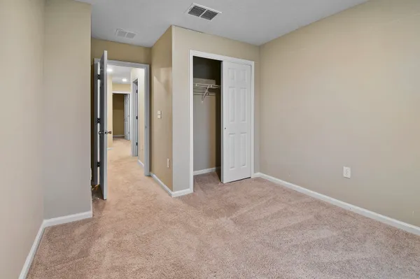 an empty room with closet and a bathroom