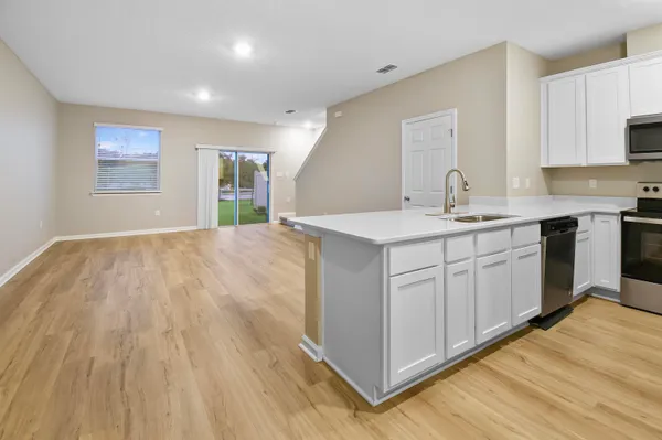 a kitchen with a sink cabinets and wooden floor