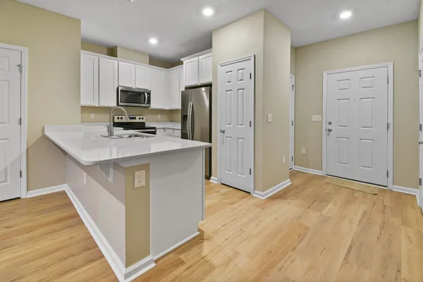 a kitchen with stainless steel appliances a refrigerator stove microwave and cabinets