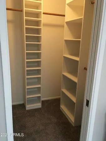 a view of walk in closet with empty racks