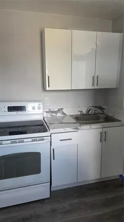 a kitchen with granite countertop white cabinets and white appliances