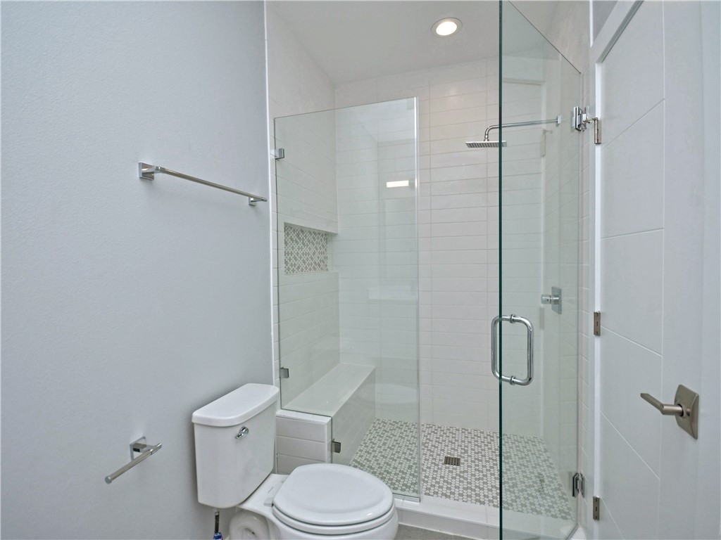 2108 Tillery Street, Unit 2102 Austin, TX 78723 - Photo 14 of 26 The primary bathroom also includes a frameless walk-in shower with a bench seat, timeliness subway tile surround, and pebble flooring.