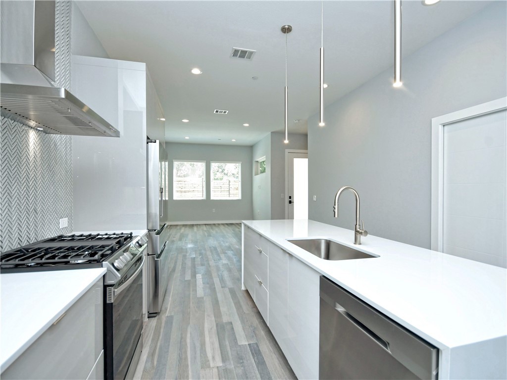 2108 Tillery Street, Unit 2102 Austin, TX 78723 - Photo 2 of 26 The kitchen is equipped with upscale stainless-steel appliances including a freestanding gas range and Frigidaire french door refrigerator.