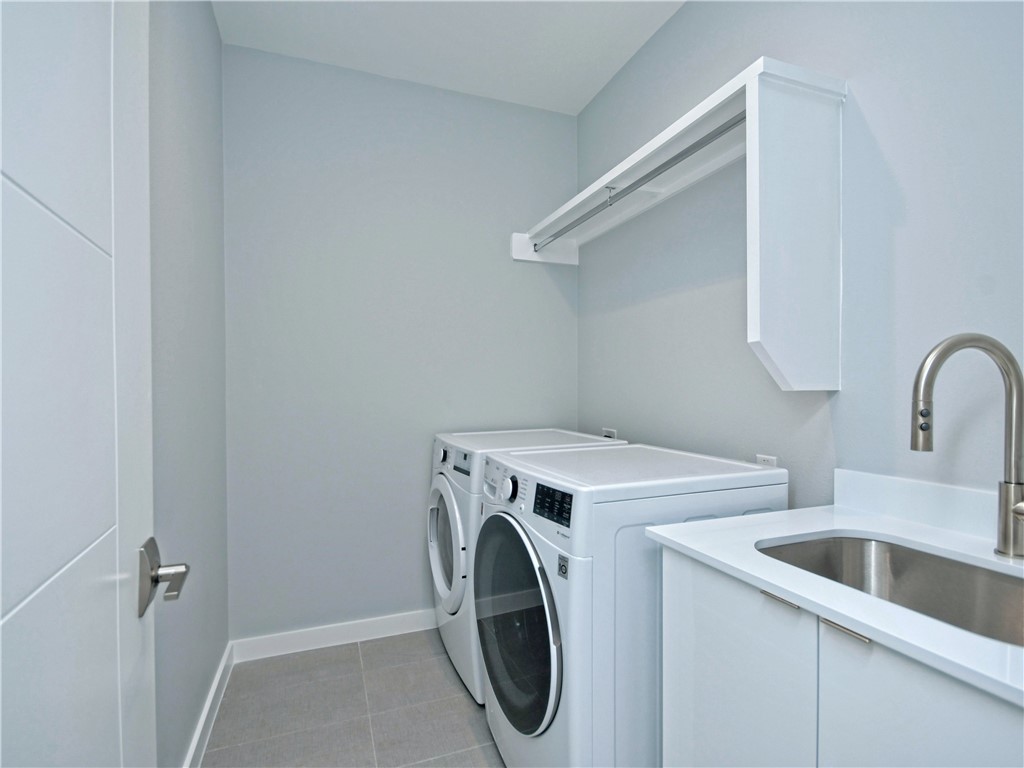 2108 Tillery Street, Unit 2102 Austin, TX 78723 - Photo 22 of 26 The laundry room is located on the second floor with shelving to store your household essentials, a convenient utility sink, and an Electrolux front-loading washer and dryer set.