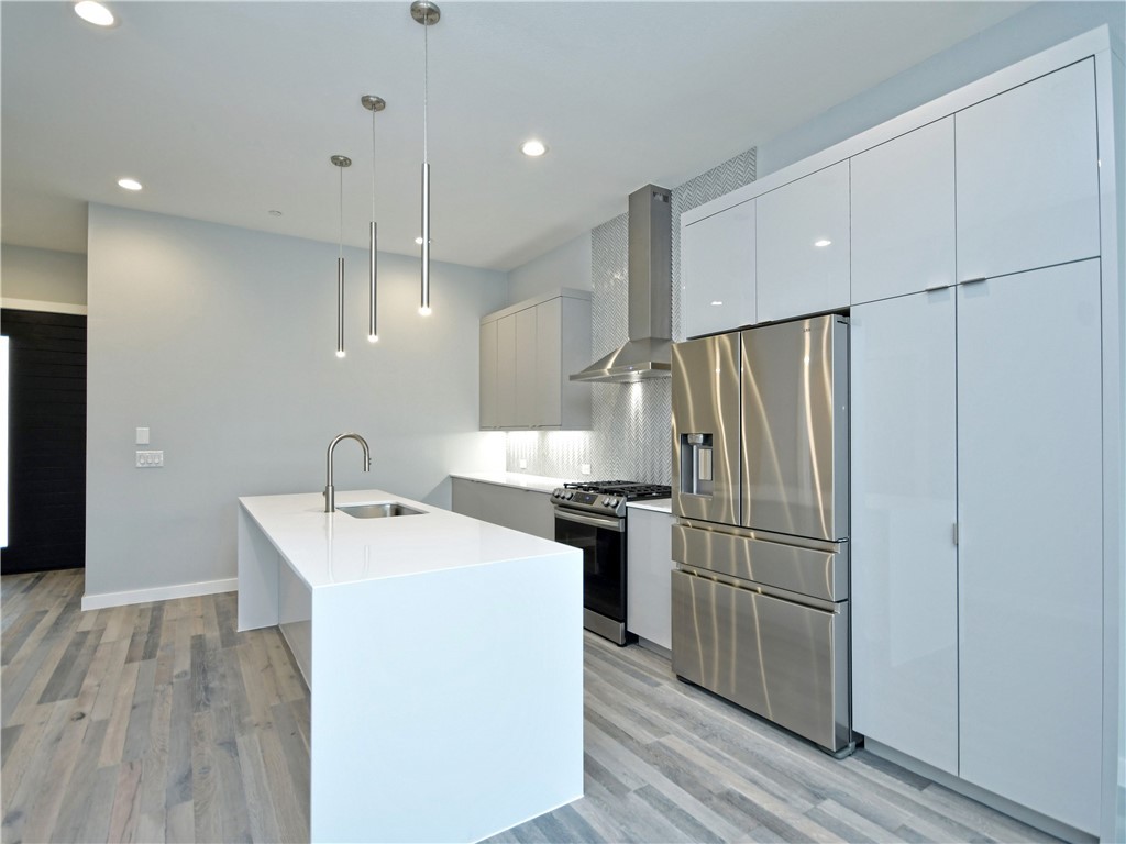 2108 Tillery Street, Unit 2102 Austin, TX 78723 - Photo 4 of 26 The kitchen is absolutely breathtaking with an extra-large center island with a waterfall quartz countertop.