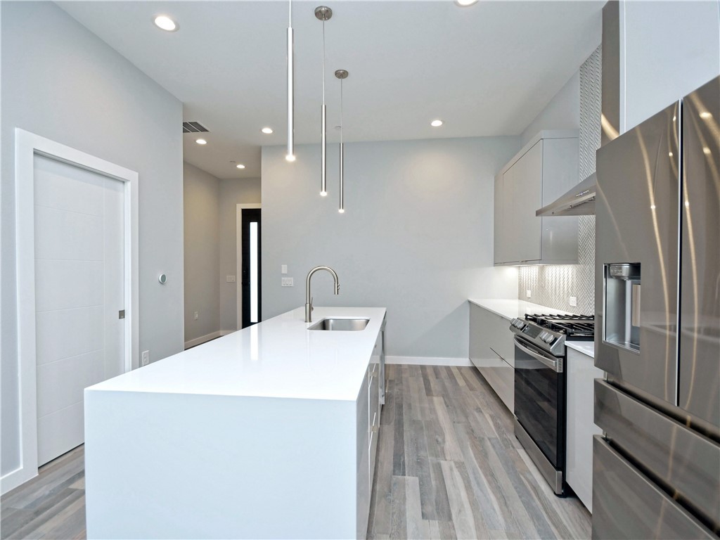 2108 Tillery Street, Unit 2102 Austin, TX 78723 - Photo 5 of 26 A pocket door off the kitchen leads to a half bathroom.