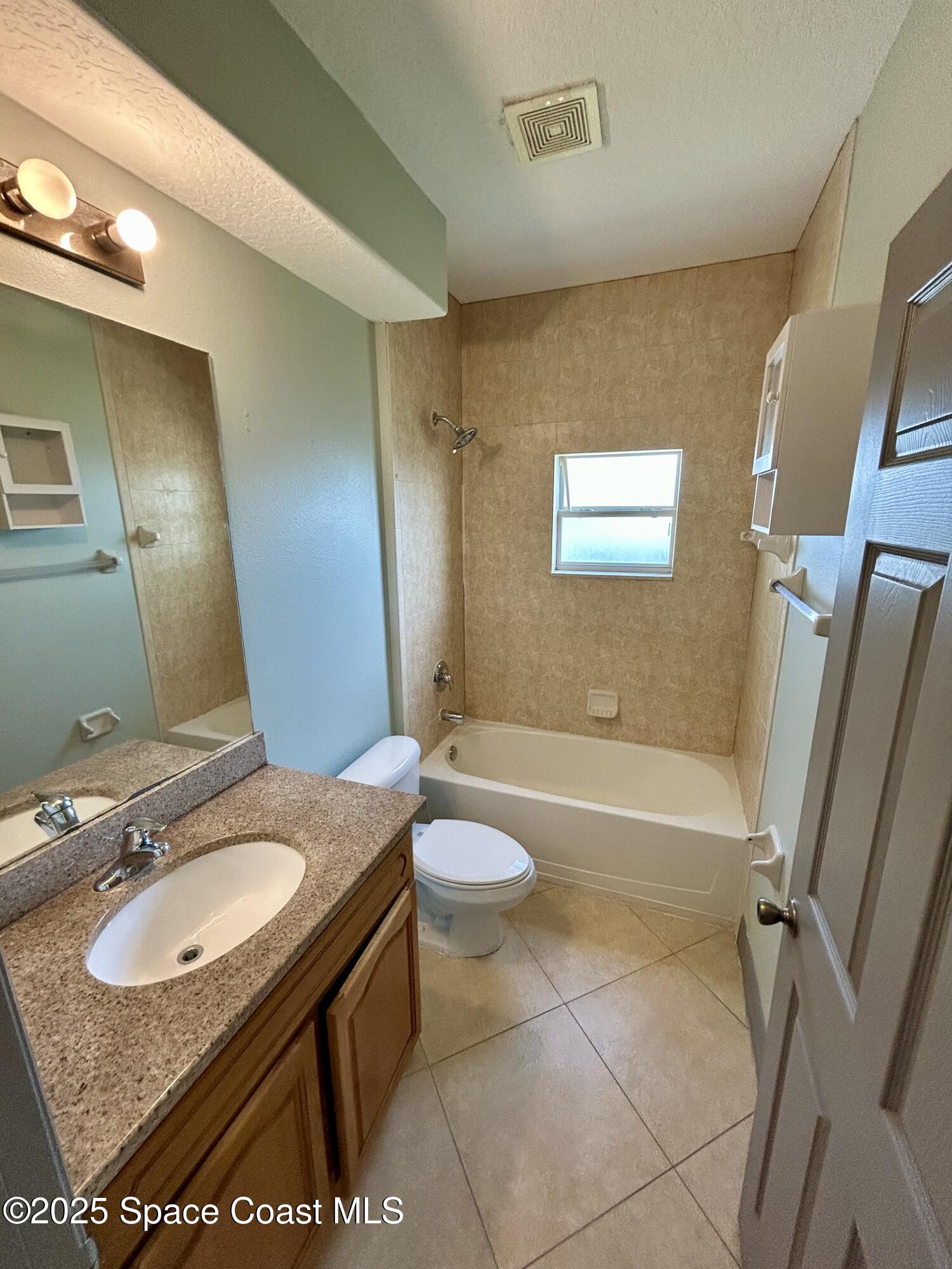 910 Twisting Branch Court Melbourne, FL 32935 - Photo 14 of 24 a bathroom with a sink a toilet and a mirror